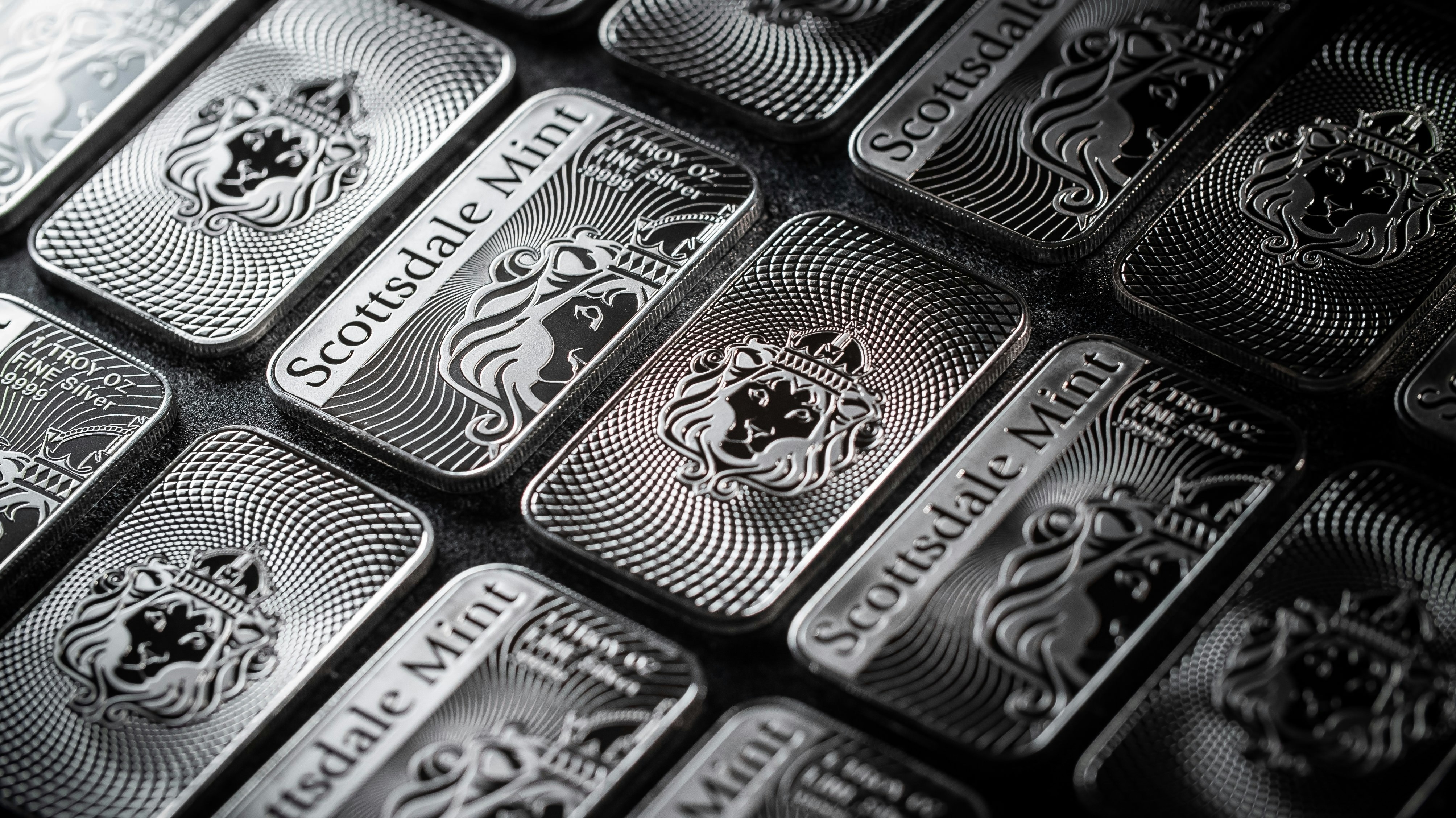 one oz silver bars lined up on a table to sell